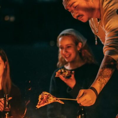 Man Heating His Pizza on a Bonfire